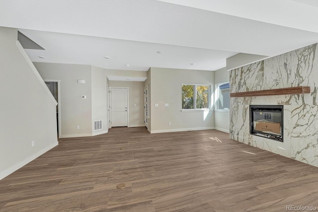 unfurnished living room featuring a premium fireplace and hardwood / wood-style floors