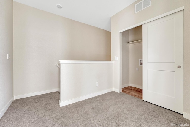 unfurnished bedroom with light carpet and a closet