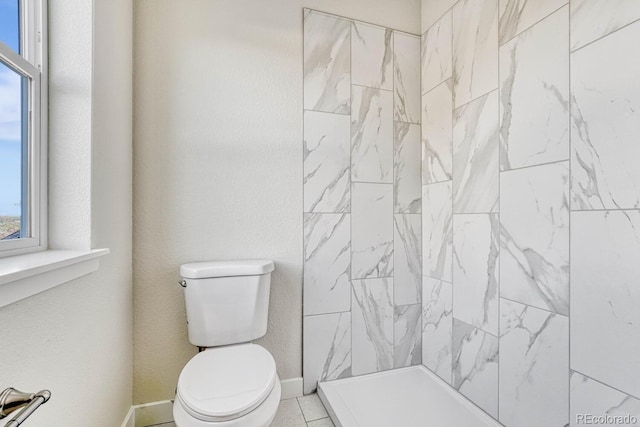 bathroom with toilet and tiled shower