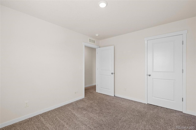 unfurnished bedroom featuring carpet, visible vents, and baseboards