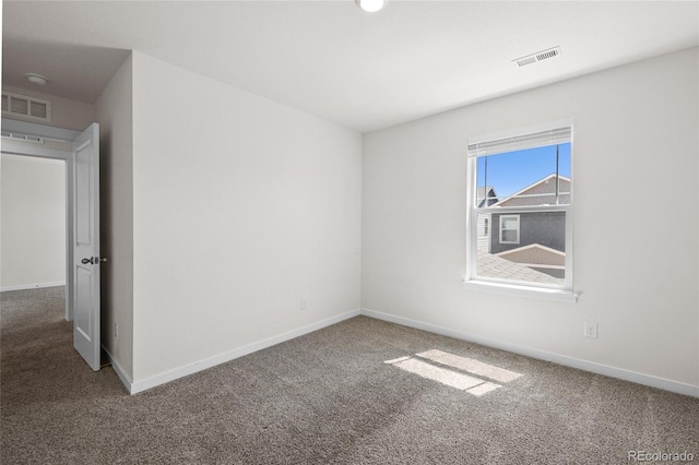 empty room featuring carpet, visible vents, and baseboards