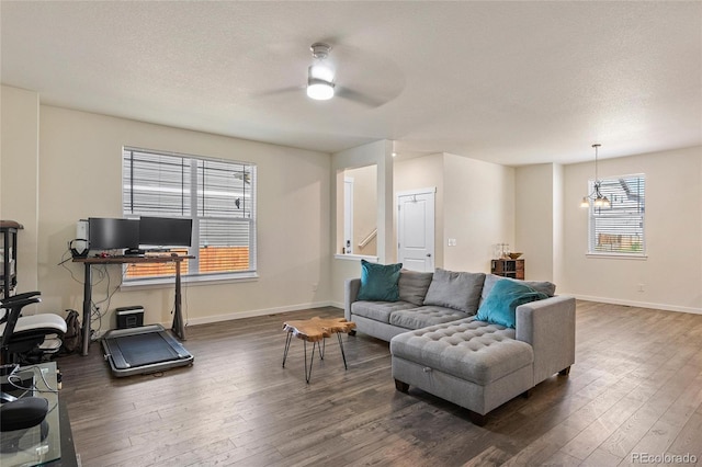 living room with dark wood finished floors, a textured ceiling, and baseboards