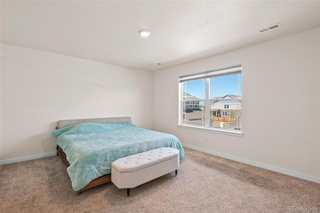 bedroom with carpet, visible vents, a textured ceiling, and baseboards