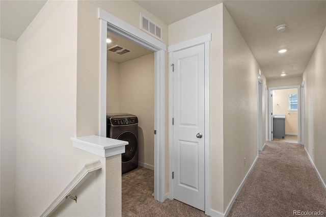 corridor featuring washer / clothes dryer, visible vents, light carpet, and baseboards