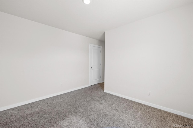 spare room featuring carpet and baseboards