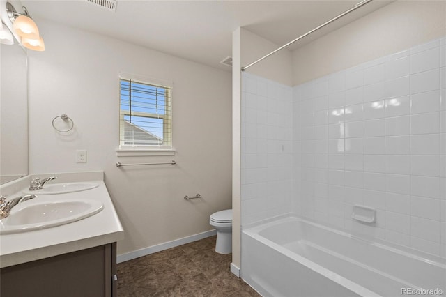 full bath featuring double vanity, baseboards, toilet, and a sink