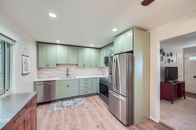 kitchen featuring sink, decorative backsplash, light hardwood / wood-style flooring, and stainless steel appliances