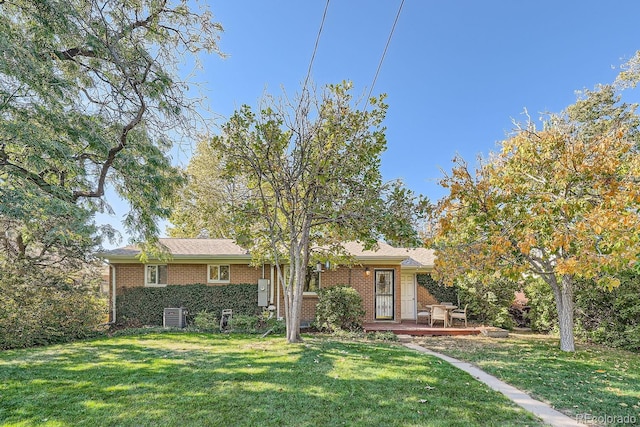 view of front of home with central air condition unit and a front lawn