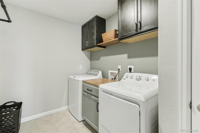 washroom with cabinets and washing machine and dryer