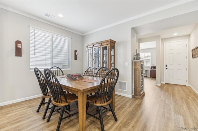 dining area with crown molding and light hardwood / wood-style flooring