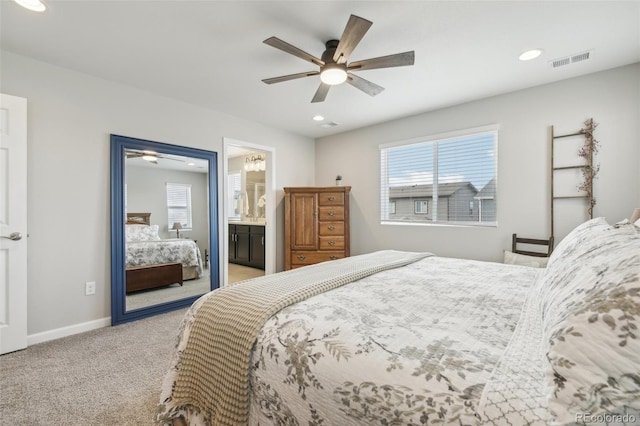 bedroom featuring ceiling fan, connected bathroom, and light colored carpet