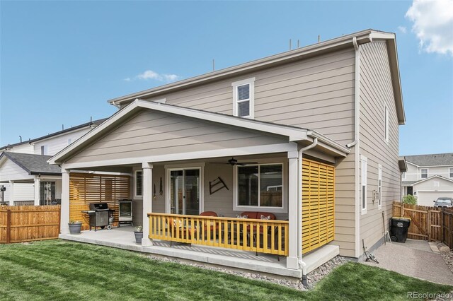 back of house with ceiling fan, a patio, and a lawn