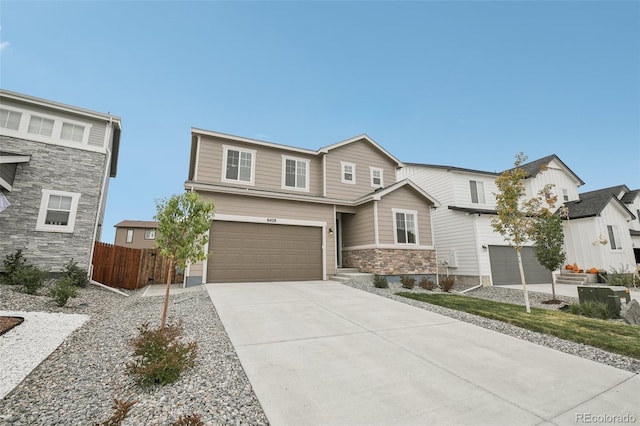 view of front of home featuring driveway, a garage, and fence