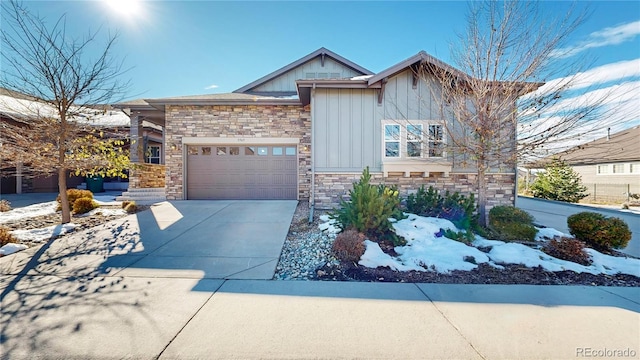 craftsman-style house featuring board and batten siding, concrete driveway, an attached garage, and stone siding