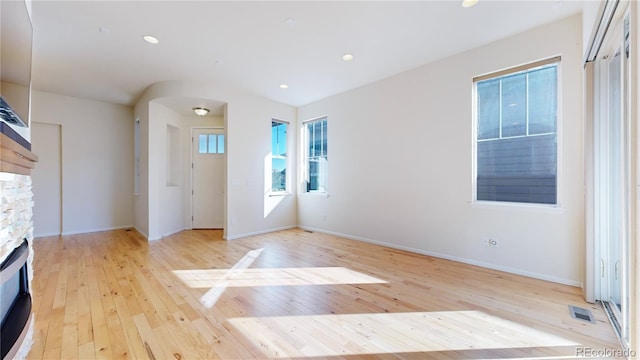 interior space with a stone fireplace and light wood-type flooring