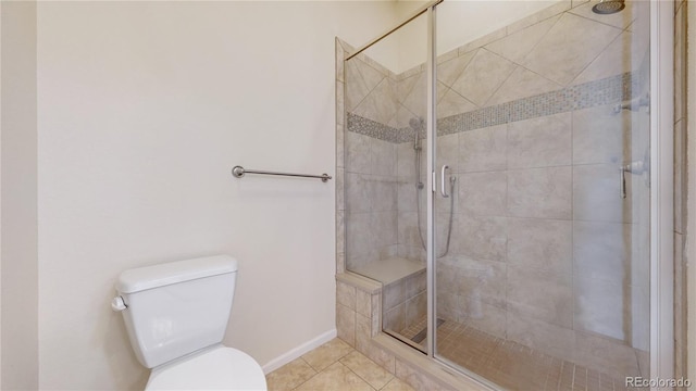 bathroom with tile patterned flooring, toilet, and a shower with shower door