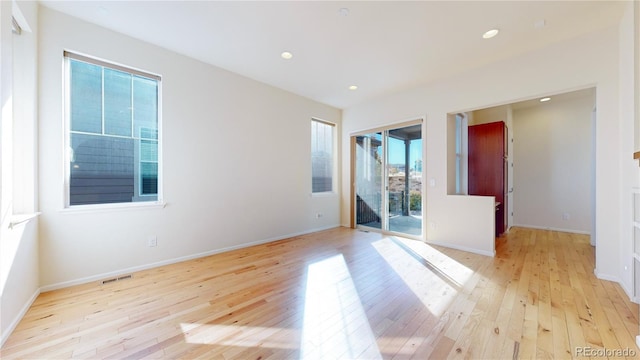 spare room featuring light hardwood / wood-style flooring and plenty of natural light