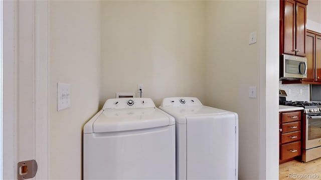 laundry area featuring light hardwood / wood-style floors, cabinets, and separate washer and dryer