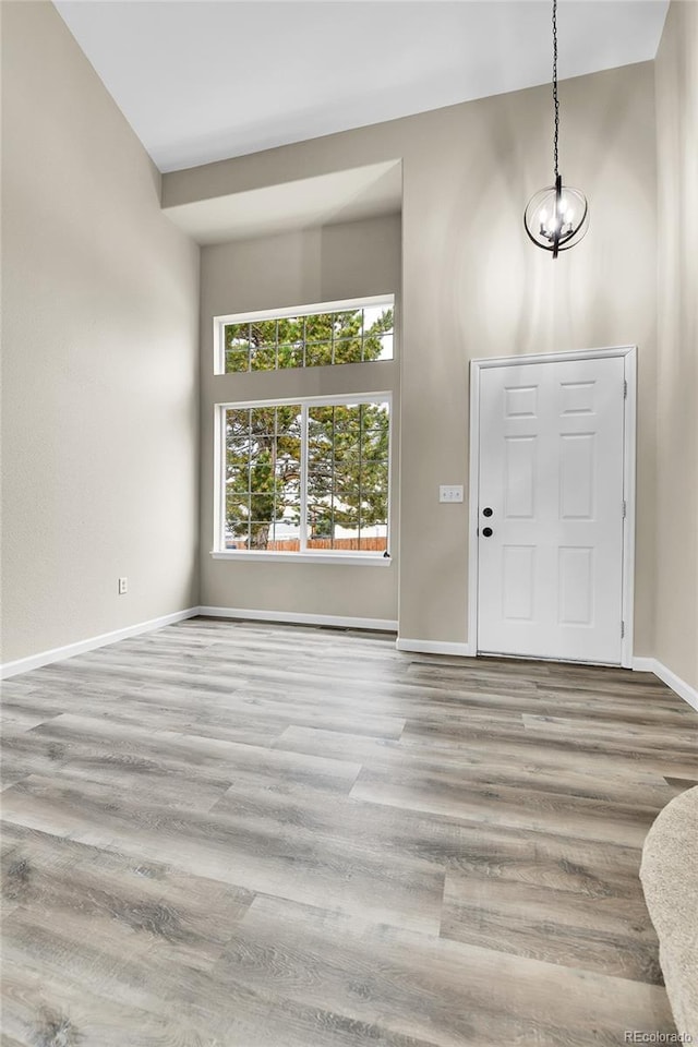 22974 E Dorado Dr, Aurora, CO 80015 - entryway with baseboards, wood finished floors, a towering ceiling, and a chandelier