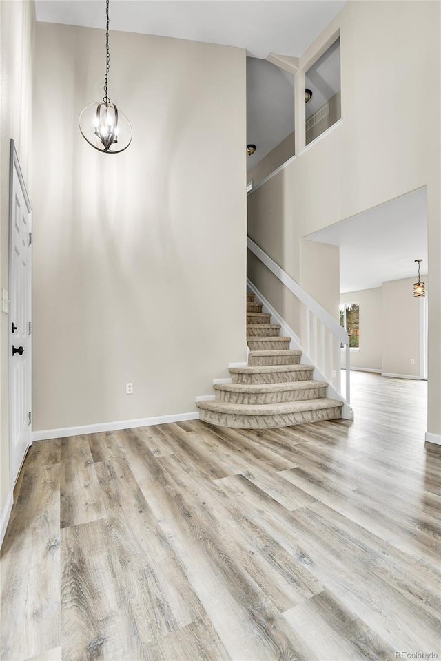 22974 E Dorado Dr, Aurora, CO 80015 - entrance foyer with stairs, wood finished floors, a towering ceiling, a chandelier, and baseboards