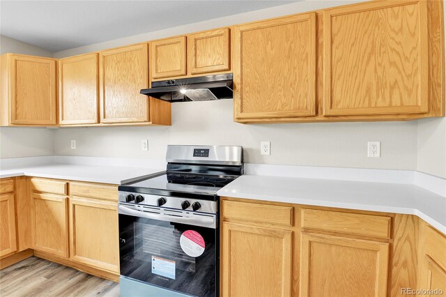 22974 E Dorado Dr, Aurora, CO 80015 - kitchen with electric range, under cabinet range hood, light brown cabinetry, and light countertops