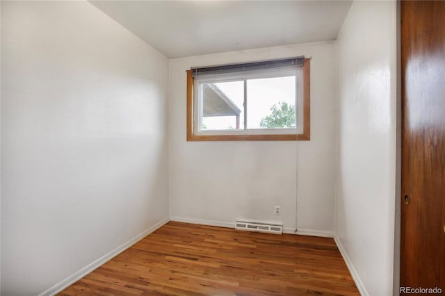 7839 Florado St, Denver, CO 80221 - empty room featuring wood finished floors and a baseboard heating unit