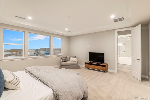 bedroom with connected bathroom and light carpet