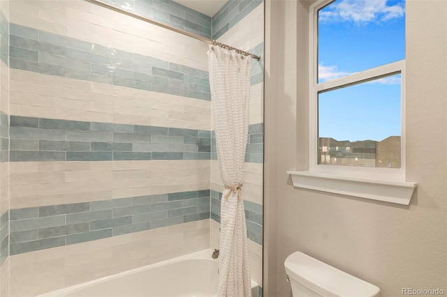 bathroom with shower / bath combo with shower curtain and toilet