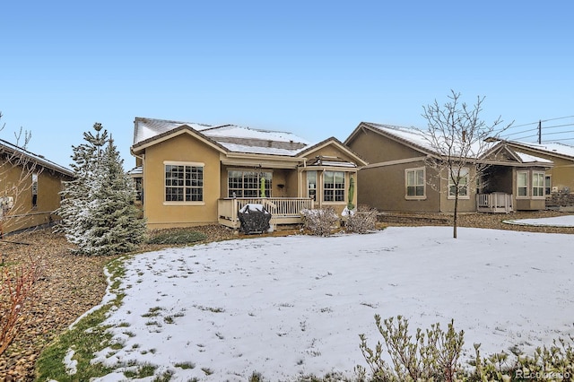 15855 Wild Horse Dr, Broomfield, CO 80023 - snow covered rear of property with stucco siding and a porch