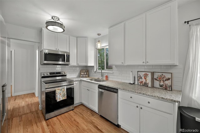 196 Jersey, Colorado Springs, CO 80911 - kitchen featuring appliances with stainless steel finishes, a sink, white cabinetry, backsplash, and light wood finished floors