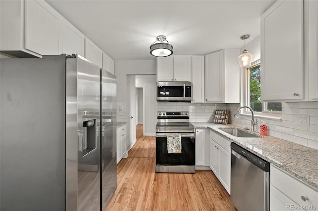 196 Jersey, Colorado Springs, CO 80911 - kitchen with appliances with stainless steel finishes, a sink, white cabinetry, and light wood-type flooring