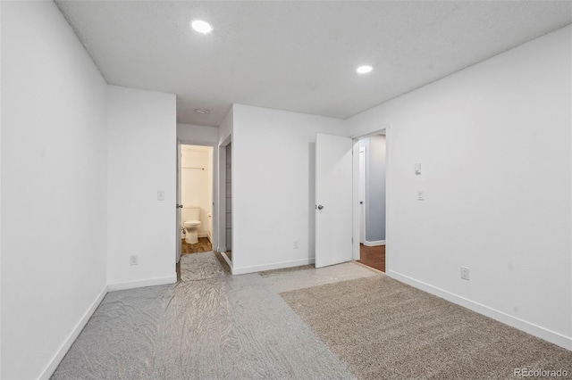 unfurnished bedroom with light colored carpet and ensuite bathroom