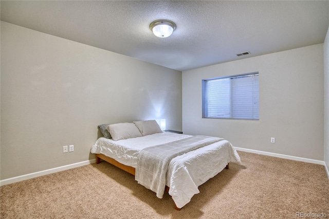 bedroom with a textured ceiling and carpet floors