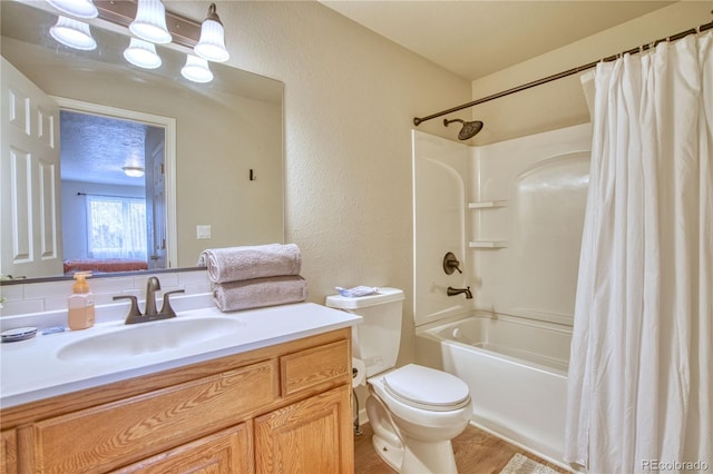 full bathroom featuring toilet, a textured ceiling, vanity, and shower / tub combo with curtain