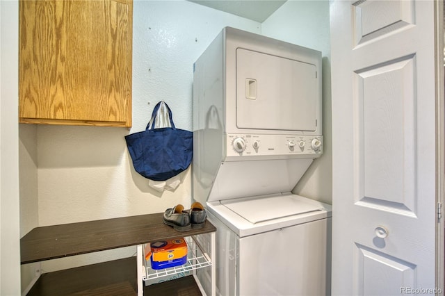 clothes washing area featuring stacked washer and clothes dryer