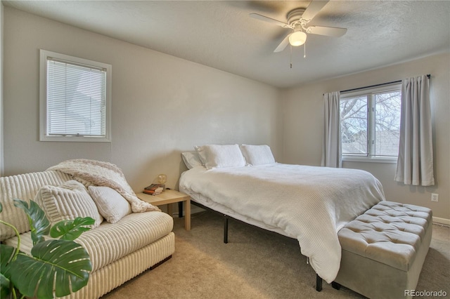 bedroom featuring light colored carpet, a textured ceiling, and ceiling fan