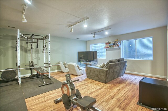 workout area featuring a textured ceiling and wood-type flooring