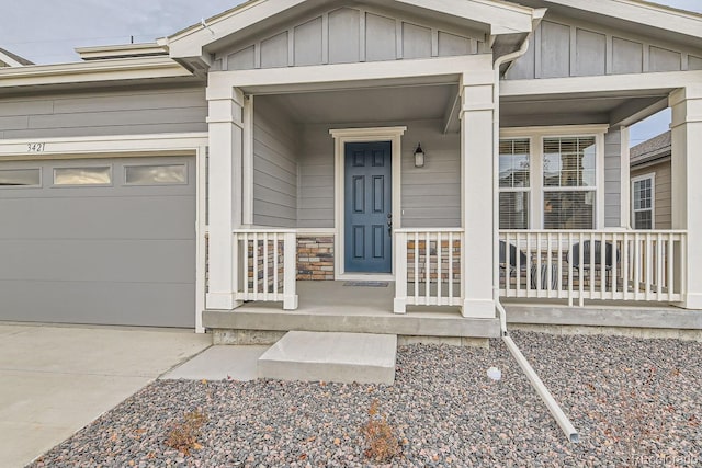 entrance to property featuring a porch and a garage