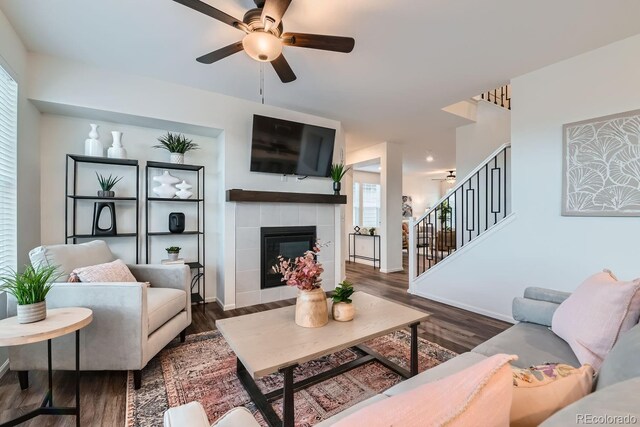 living room featuring a fireplace, dark hardwood / wood-style flooring, and ceiling fan