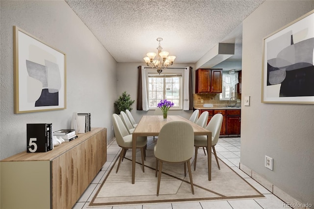 tiled dining area featuring sink, a textured ceiling, and an inviting chandelier