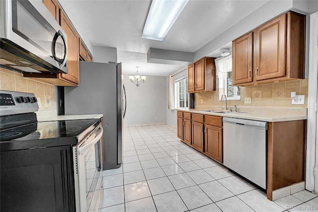 kitchen featuring light tile patterned floors, decorative backsplash, sink, and stainless steel appliances