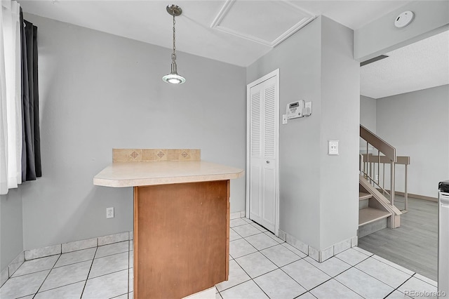 kitchen featuring pendant lighting, light tile patterned floors, and kitchen peninsula