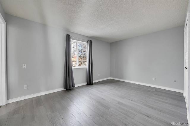 empty room featuring a textured ceiling and hardwood / wood-style flooring