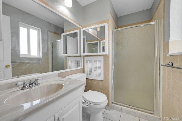 bathroom with an enclosed shower, vanity, tile walls, and toilet