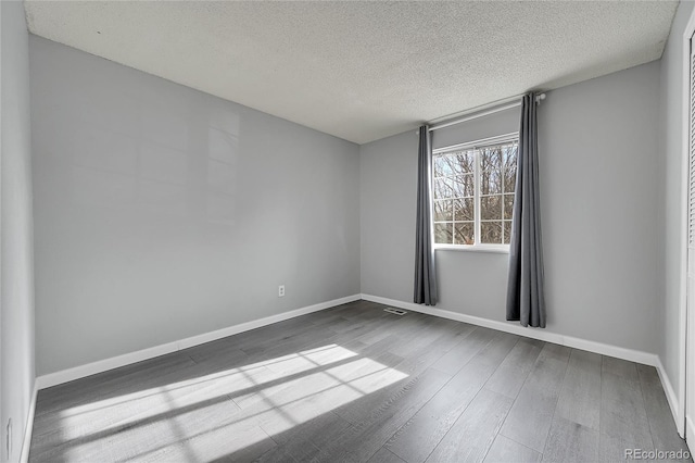 spare room with wood-type flooring and a textured ceiling