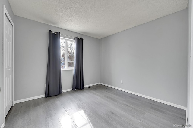 spare room with wood-type flooring and a textured ceiling