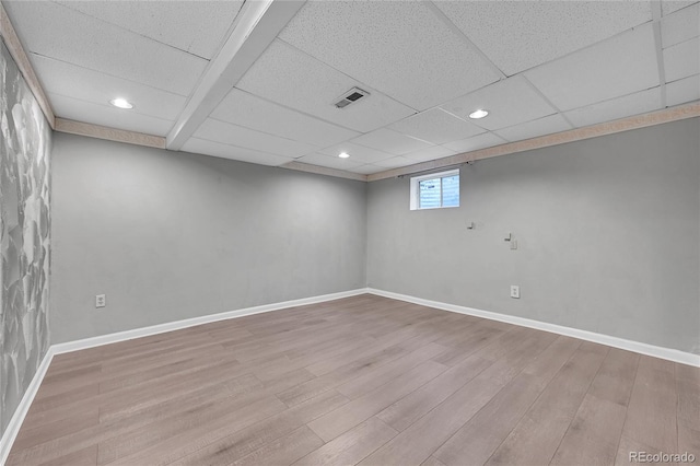 basement with a drop ceiling and light wood-type flooring