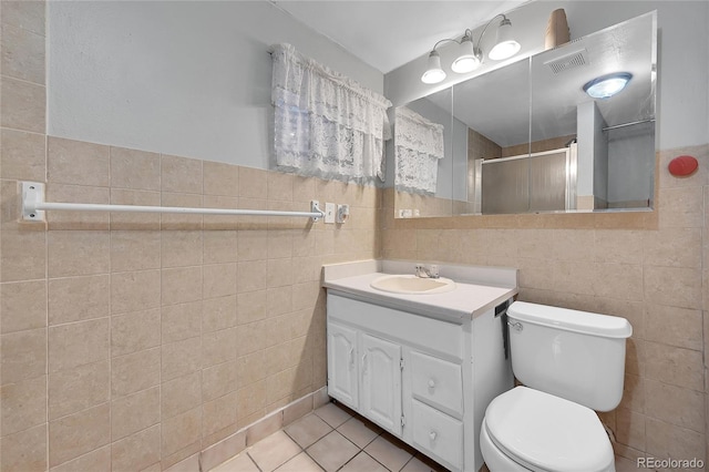 bathroom with toilet, tile walls, tile patterned floors, an enclosed shower, and vanity