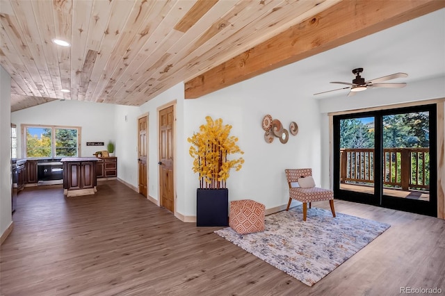 living area featuring vaulted ceiling with beams, hardwood / wood-style flooring, wooden ceiling, and ceiling fan