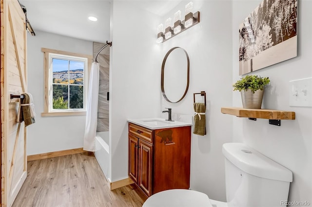 full bathroom featuring wood-type flooring, vanity, shower / bath combo with shower curtain, and toilet